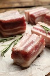 Photo of Raw ribs with rosemary on parchment paper, closeup