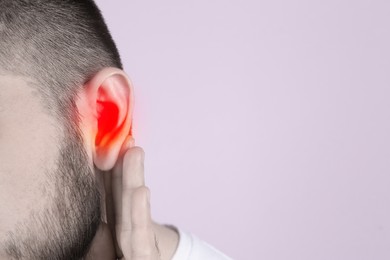 Image of  Man suffering from earache on light background, closeup. Space for text 