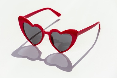 Stylish heart shaped sunglasses on white background