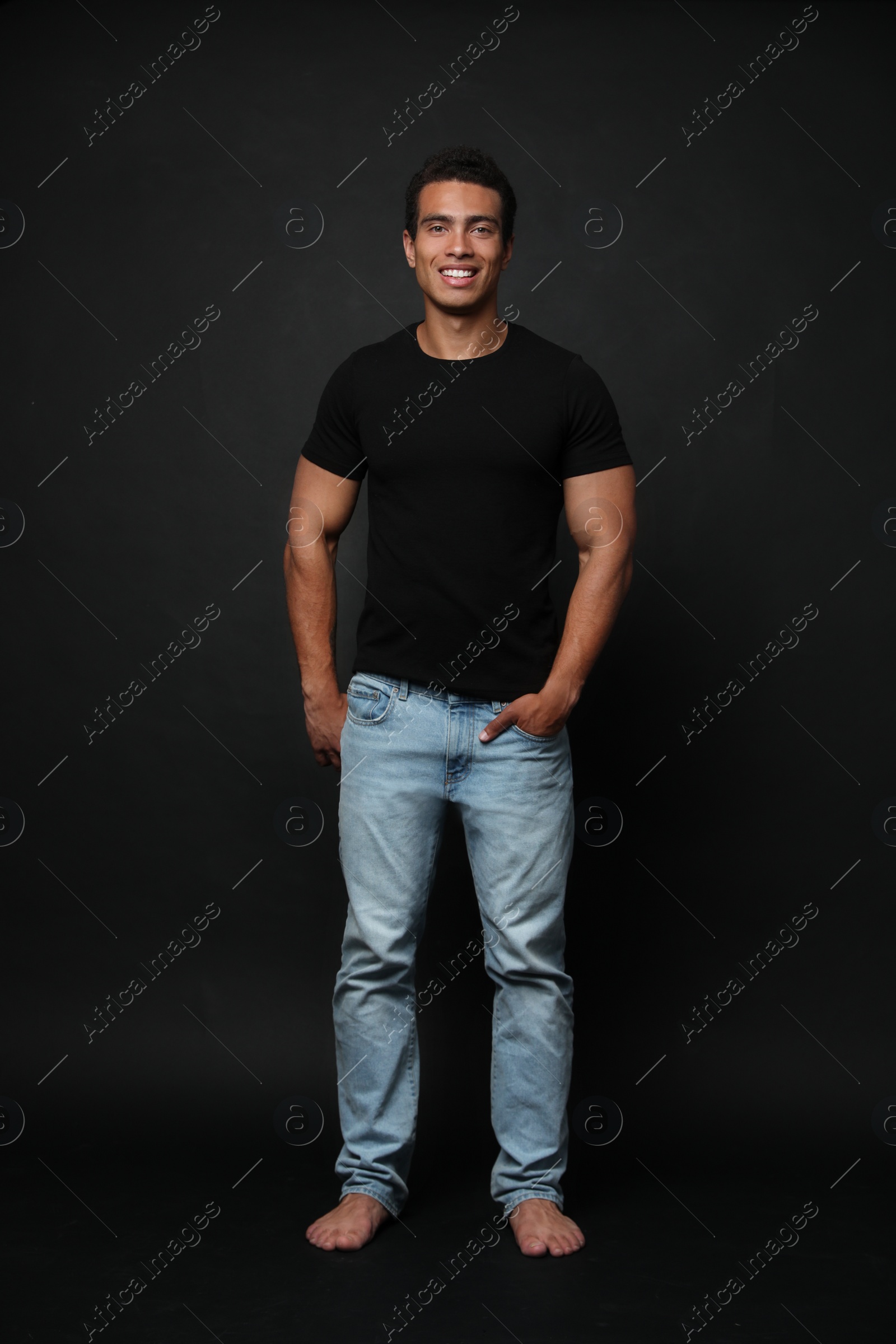 Photo of Handsome young African-American man on black background