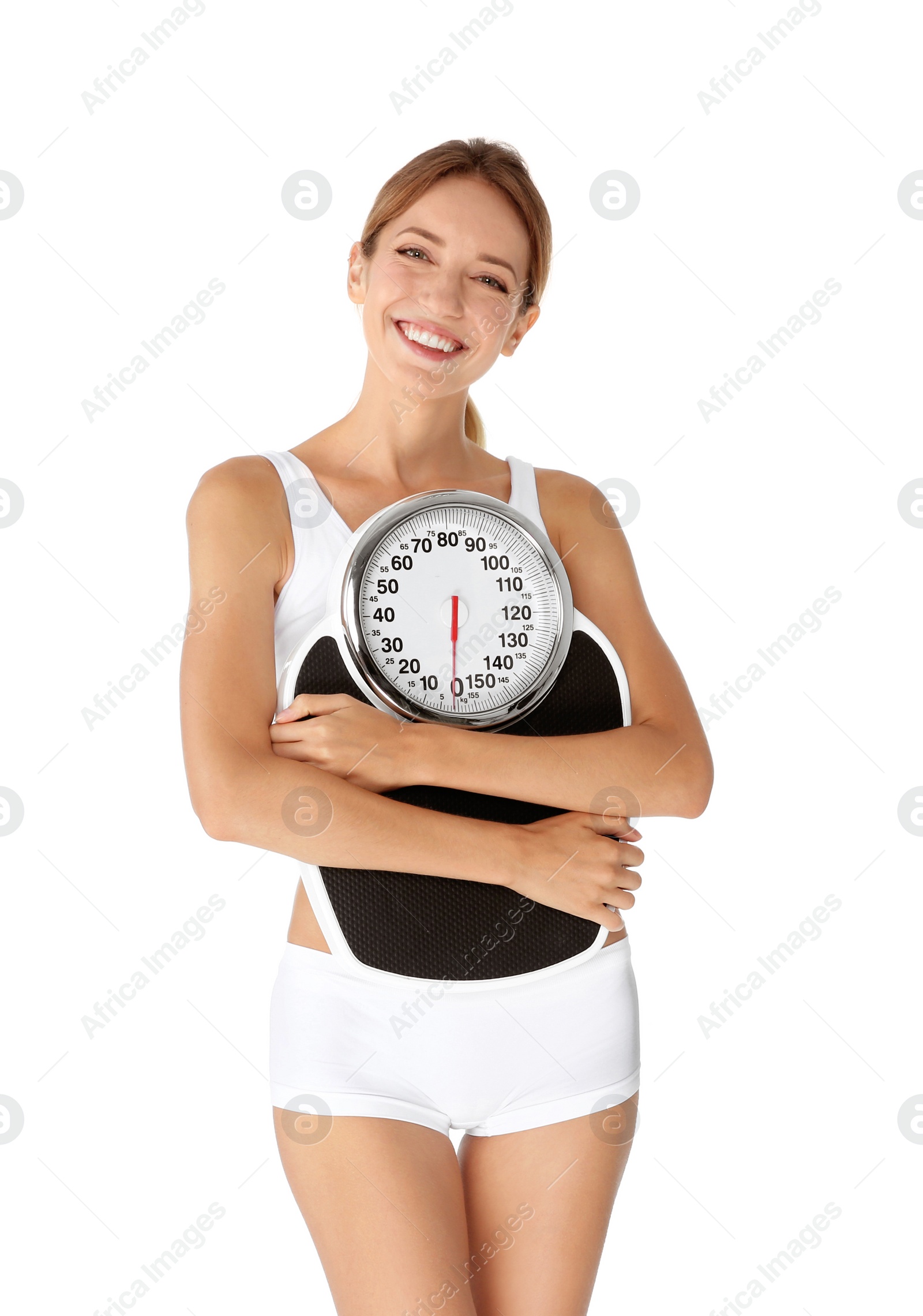 Photo of Happy slim woman satisfied with her diet results holding bathroom scales on white background