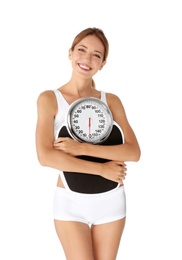 Happy slim woman satisfied with her diet results holding bathroom scales on white background