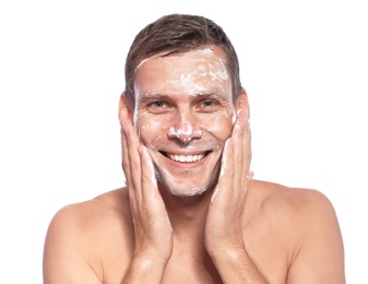 Man washing face with soap on white background