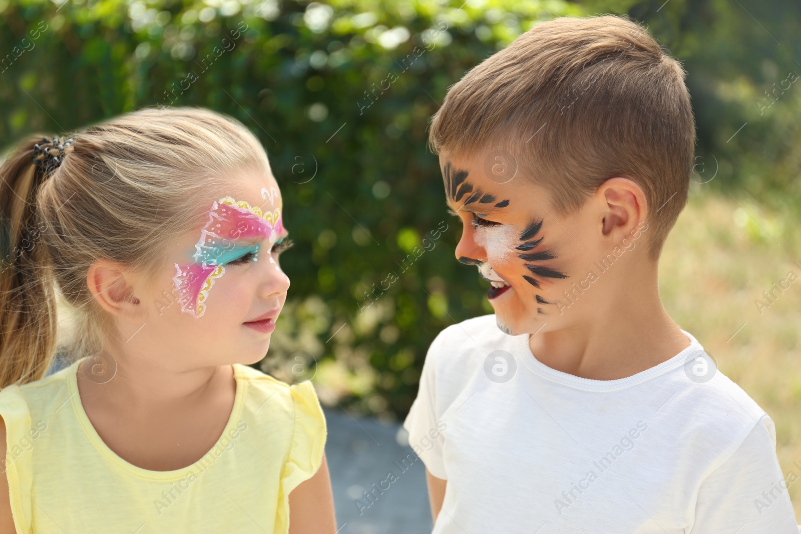 Photo of Cute little children with face painting outdoors