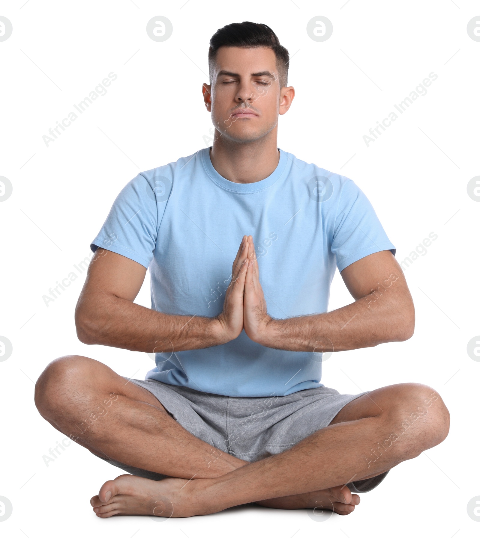 Photo of Handsome man meditating on white background. Harmony and zen