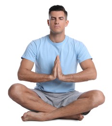 Handsome man meditating on white background. Harmony and zen