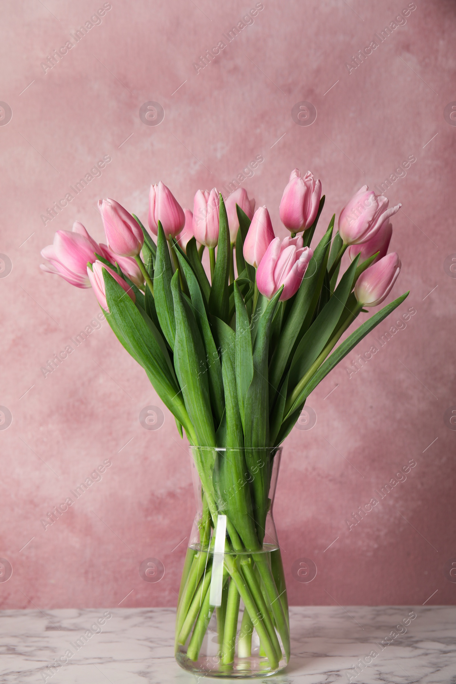 Photo of Beautiful pink spring tulips on marble table