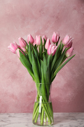 Photo of Beautiful pink spring tulips on marble table