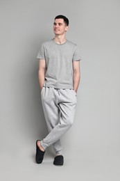 Happy man in pyjama on grey background