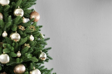 Photo of Beautiful Christmas tree with decor against light grey background. Space for text