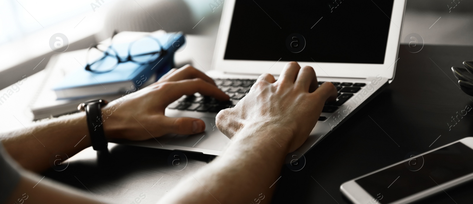 Image of Young man working on computer at table indoors, closeup. Banner design