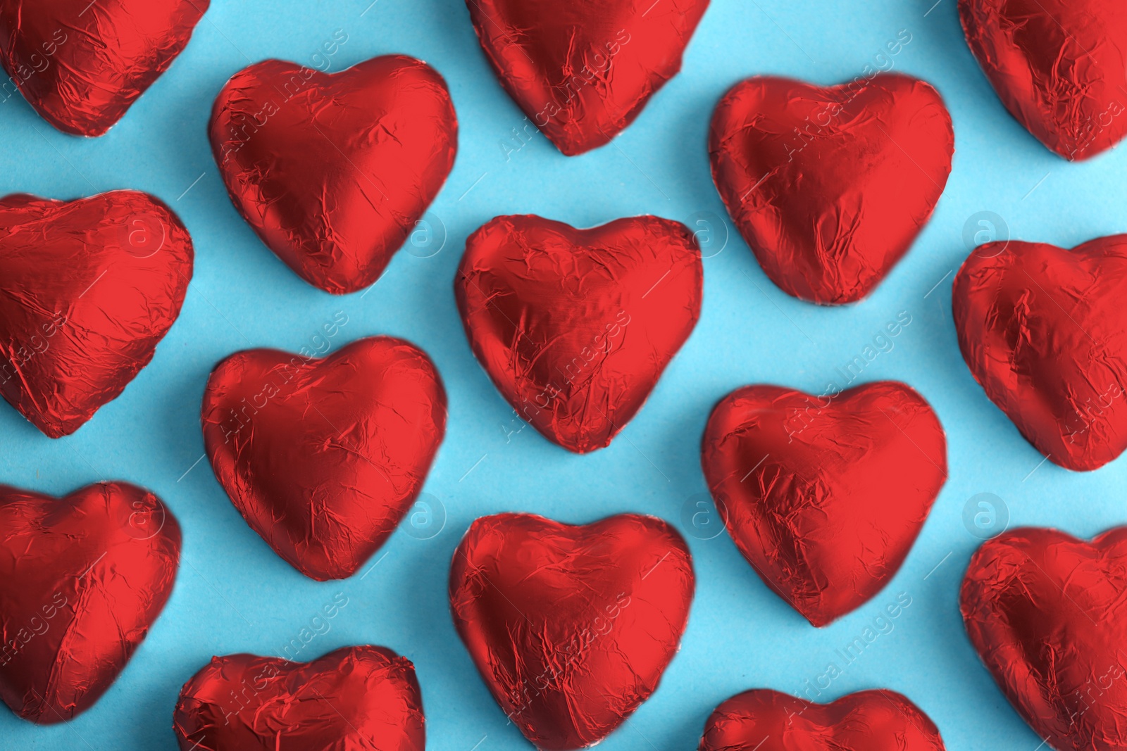 Photo of Flat lay composition with heart shaped candies on color background