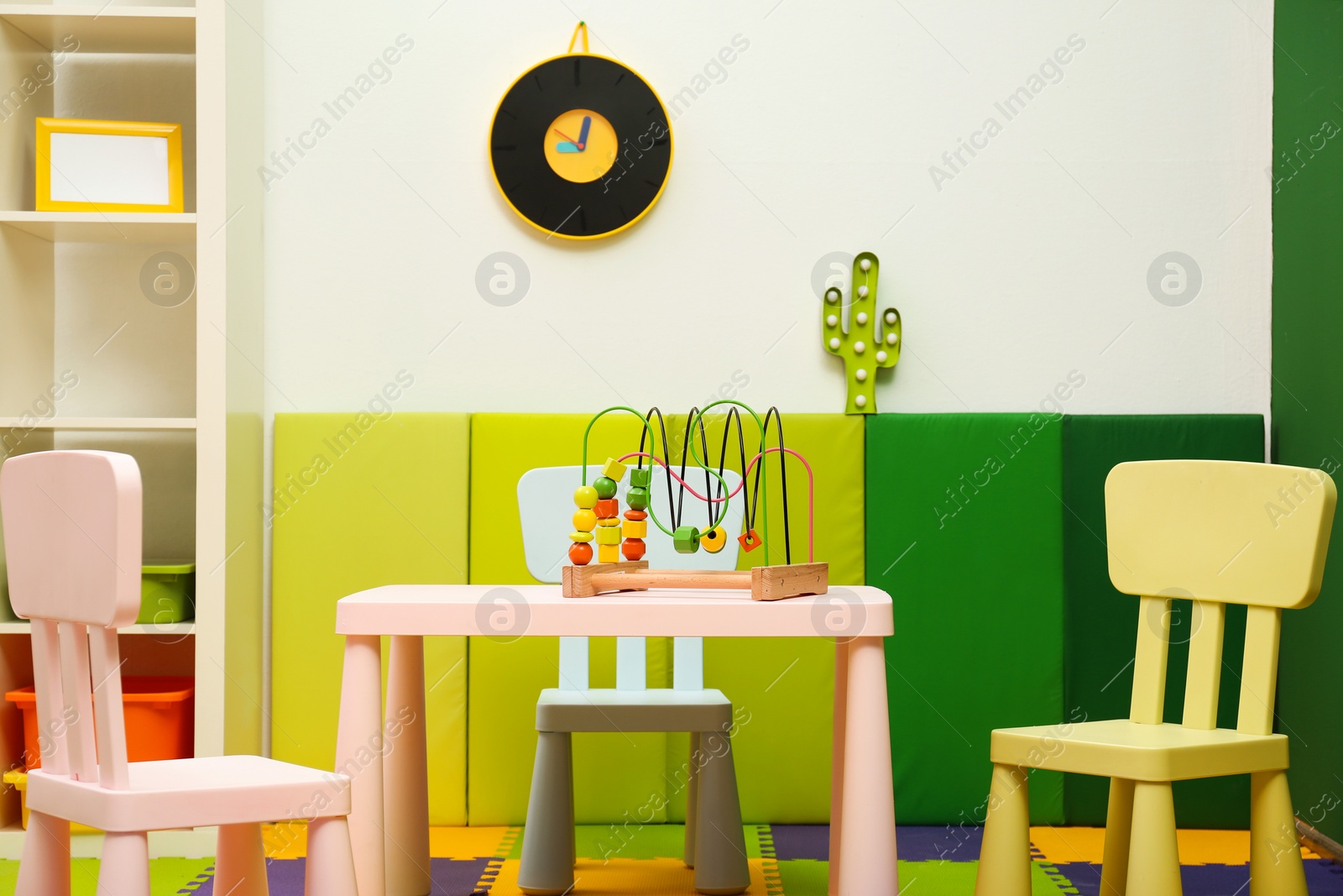 Photo of Stylish playroom interior with table and chairs