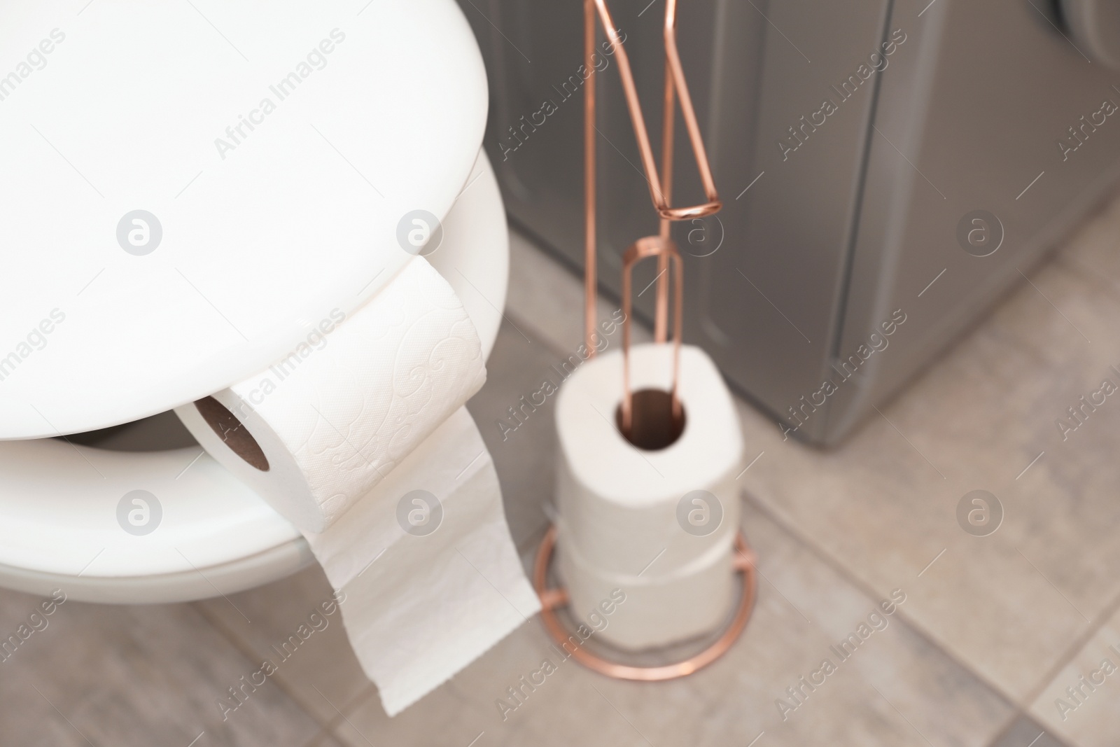 Photo of Toilet bowl with paper roll in bathroom