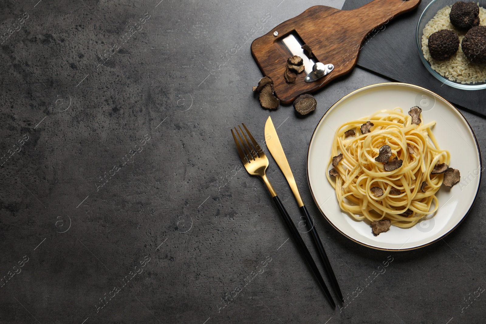 Photo of Tasty fettuccine with truffle served on grey table, flat lay. Space for text