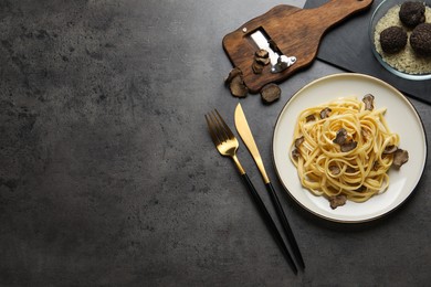 Photo of Tasty fettuccine with truffle served on grey table, flat lay. Space for text