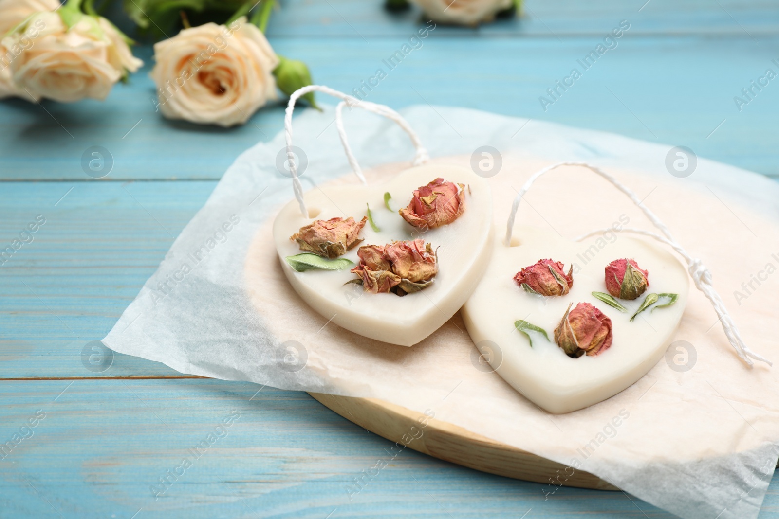 Photo of Tray with scented sachets on light blue wooden table 