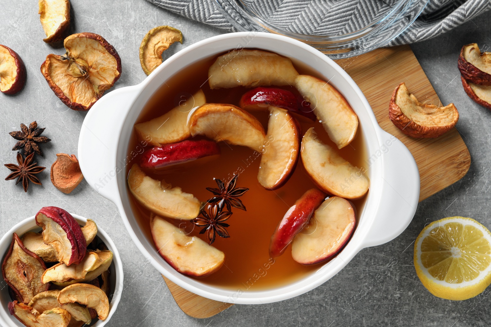 Photo of Delicious compote with dried apple slices and anise in pot on grey table, flat lay