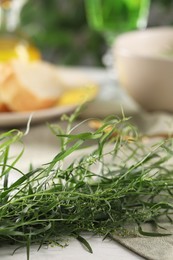 Fresh tarragon sprigs on white table. Space for text