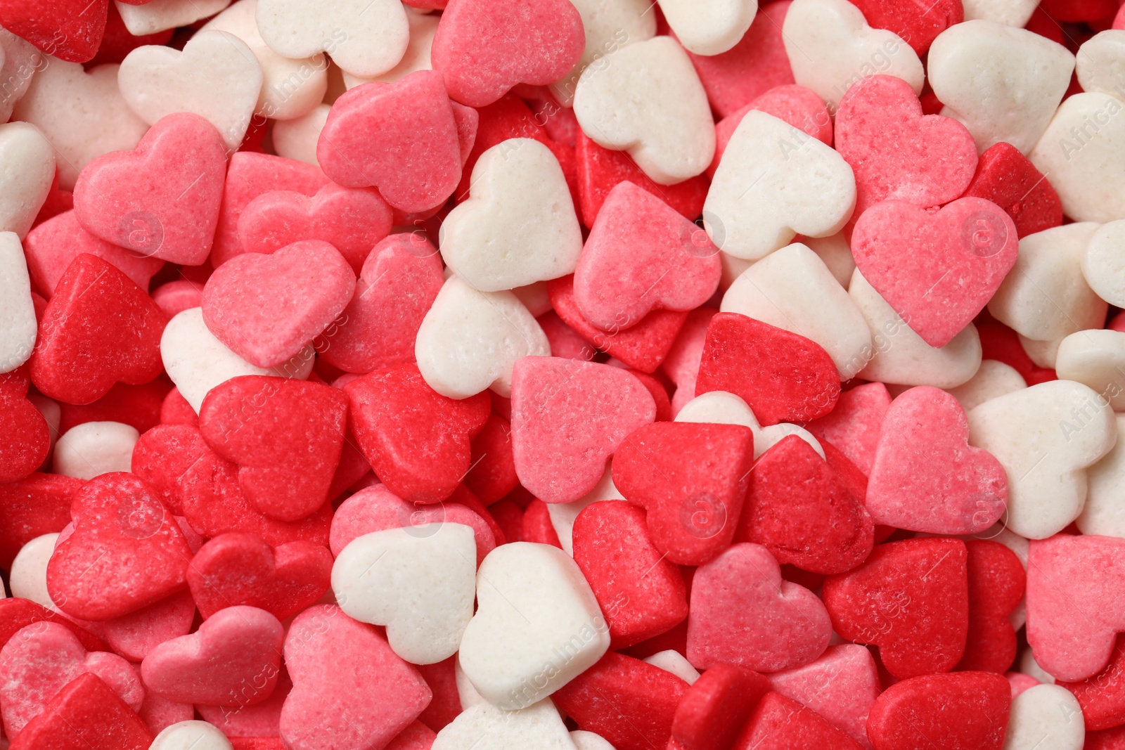 Photo of Sweet candy hearts as background, top view