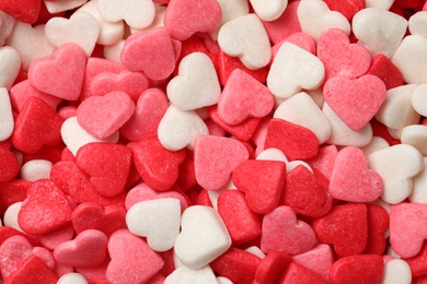 Sweet candy hearts as background, top view