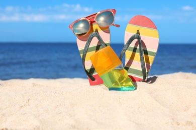 Photo of Composition with beach accessories on sand near sea in summer. Space for text