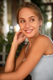 Beautiful young woman sitting on indoor terrace in cafe