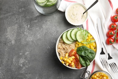 Photo of Healthy quinoa salad with vegetables in bowl served on grey table, top view. Space for text