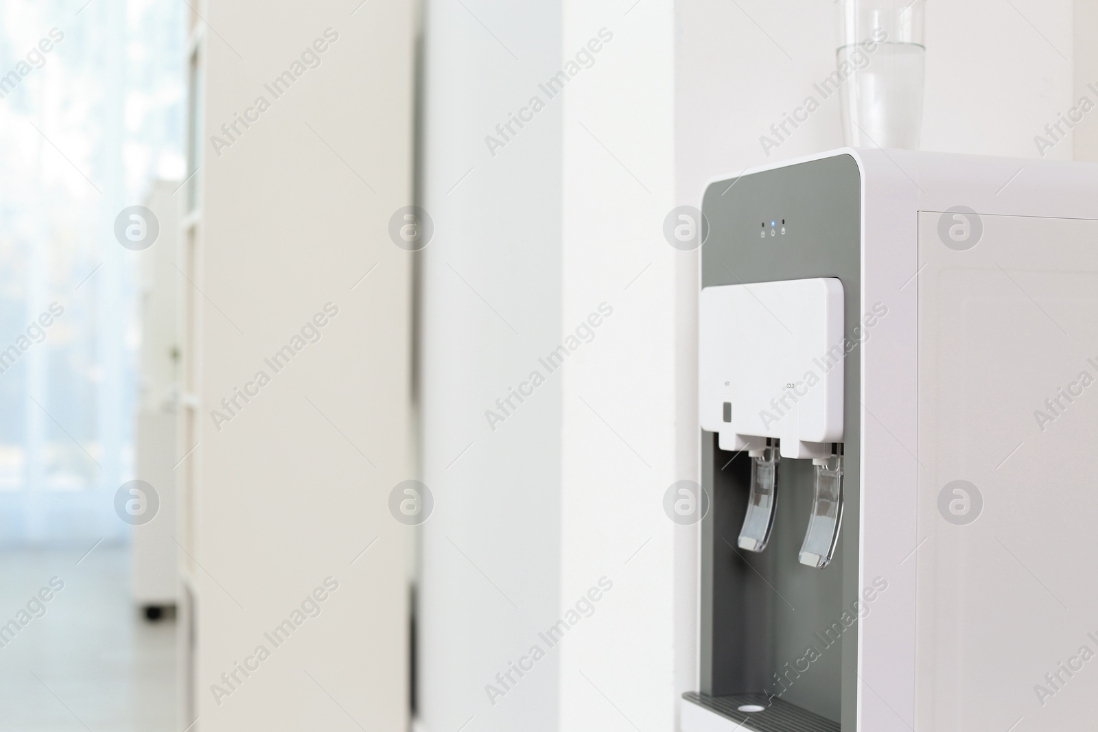 Photo of Modern water cooler indoors. Space for text