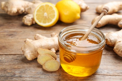 Photo of Ginger, honey and lemon on wooden table. Natural cold remedies