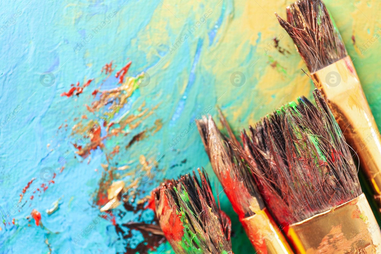 Photo of Abstract colorful artwork and brushes, closeup view