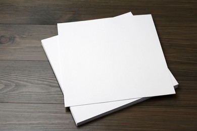 Photo of Stack of blank paper sheets on wooden table. Brochure design