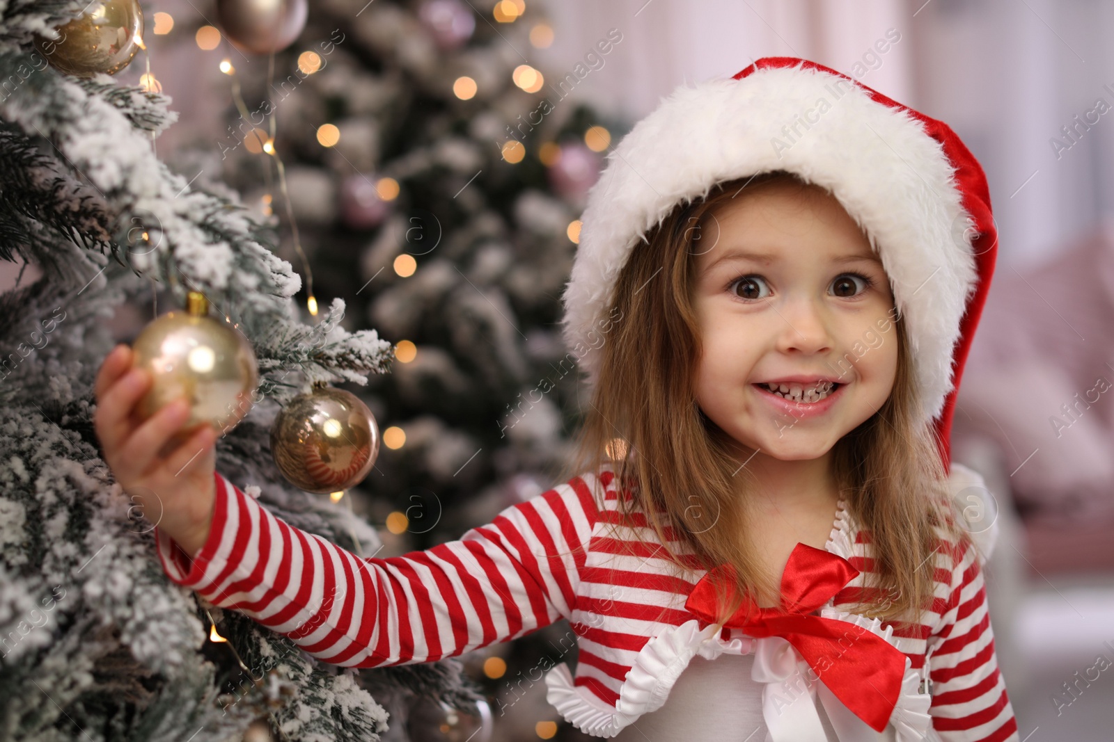 Photo of Cute little child near Christmas tree at home