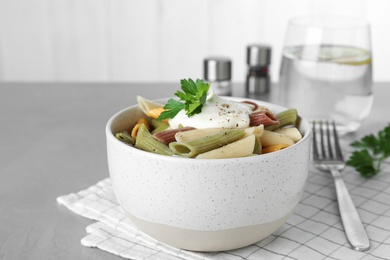 Delicious pasta with sour cream on light grey table