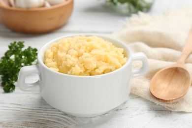 Bowl with mashed potatoes on wooden table