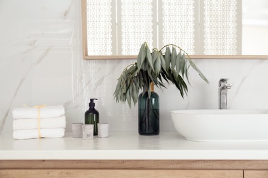 Photo of Fresh towels, candles and vessel sink on countertop in bathroom. Interior design