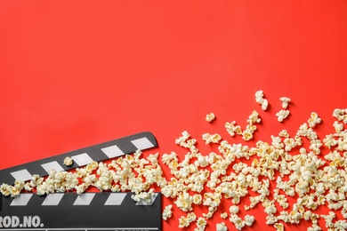 Photo of Popcorn and clapperboard on color background, top view with space for text. Cinema snack