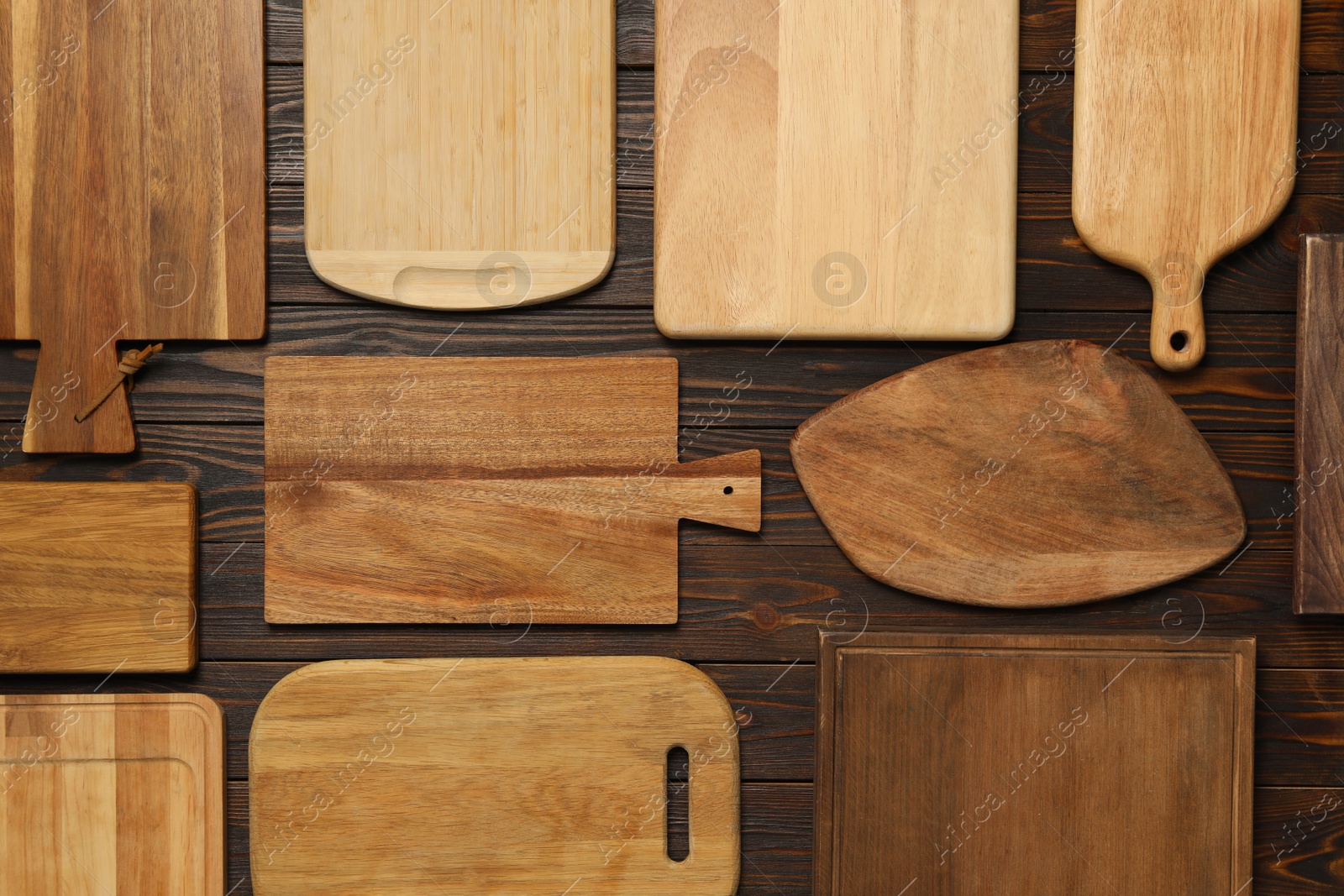 Photo of Set of wooden boards on brown table, flat lay. Cooking utensils