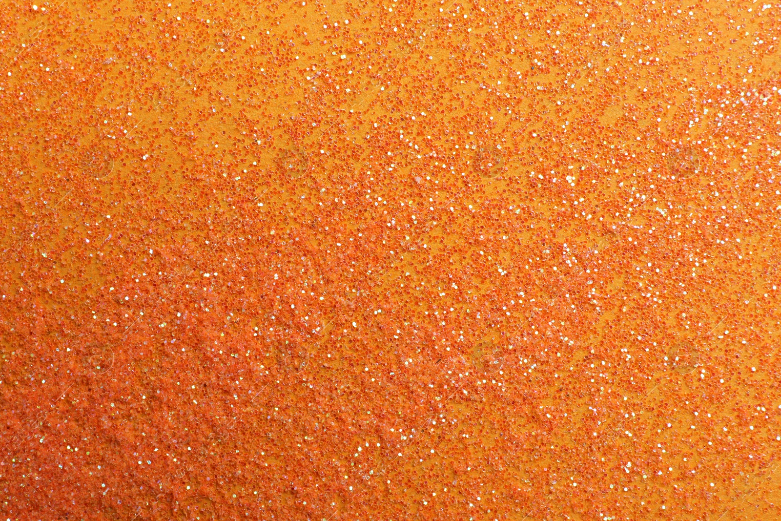 Photo of Shiny bright glitter on orange background, flat lay