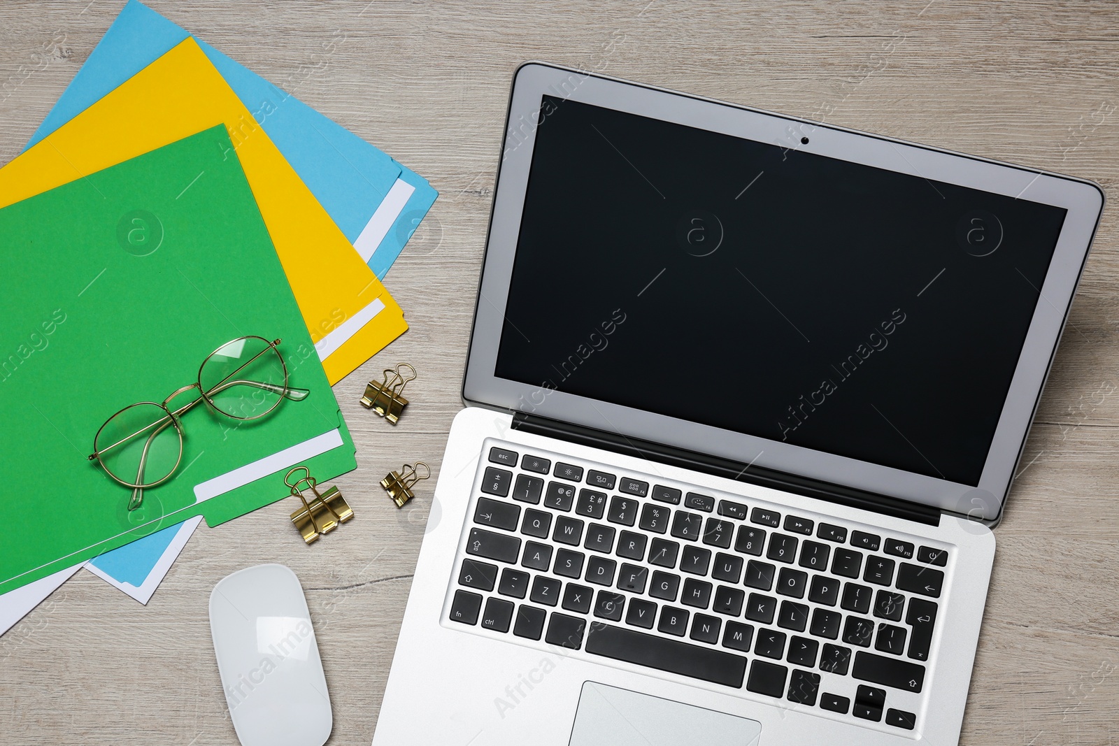 Photo of Modern laptop, glasses and office stationery on white wooden table, flat lay. Distance learning