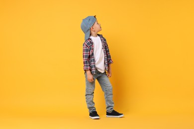 Photo of Happy little boy dancing on yellow background