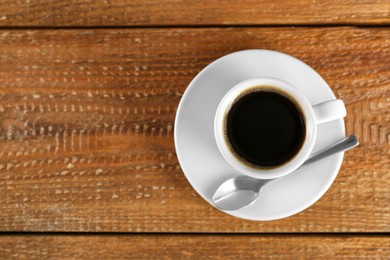Photo of Cup of tasty coffee on wooden table, top view. Space for text