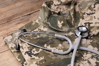 Photo of Stethoscope and military uniform on wooden table