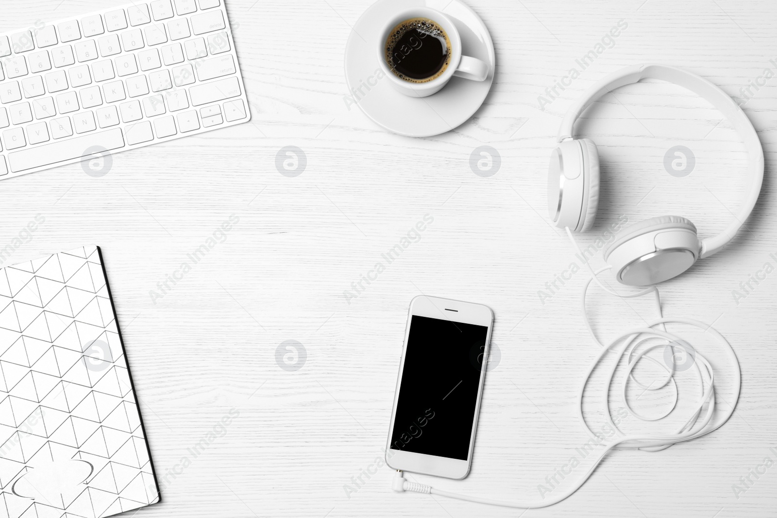 Photo of Flat lay composition with headphones, smartphone, computer keyboard and space for text on white wooden background