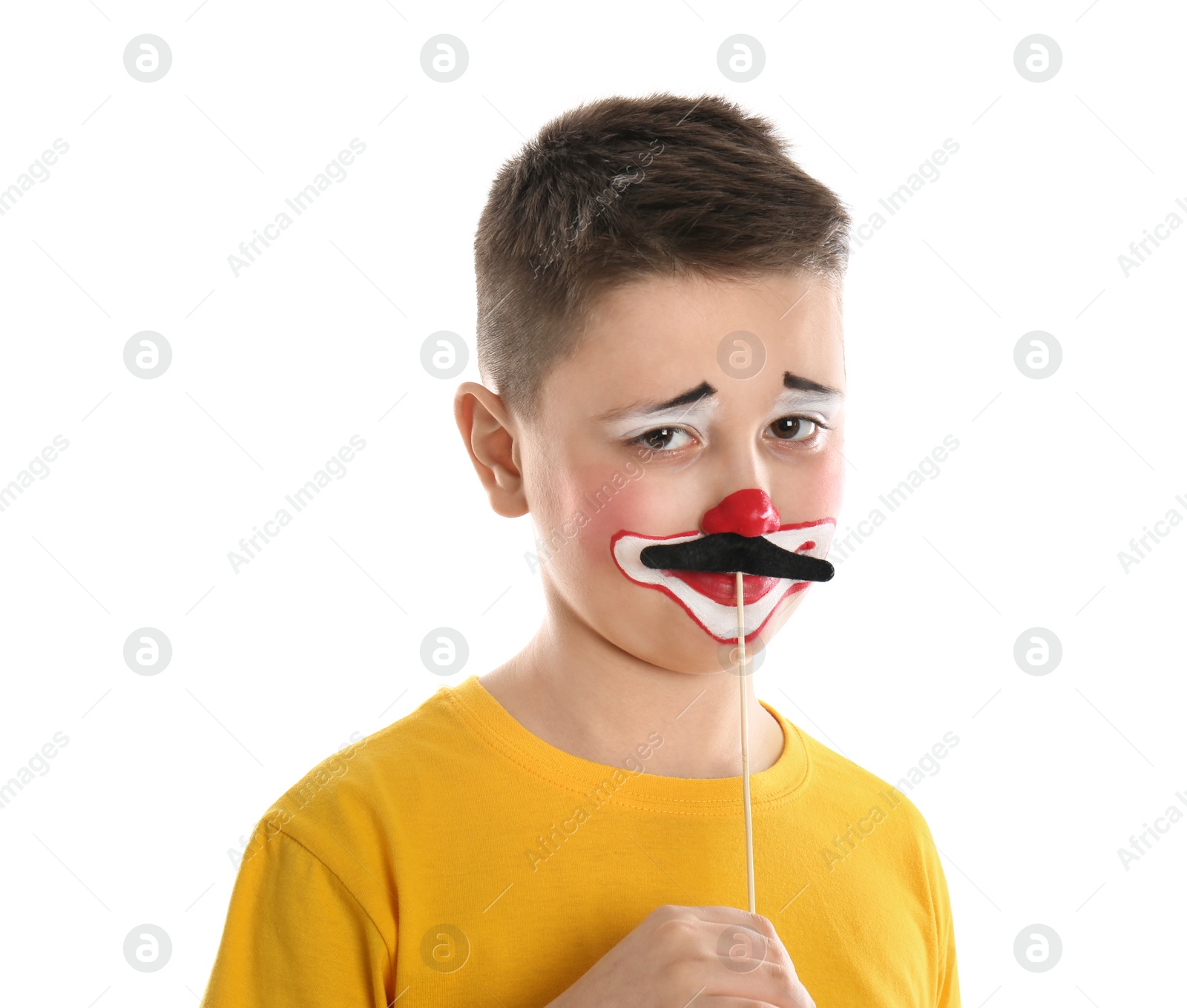 Photo of Preteen boy with clown makeup and fake mustache on white background. April fool's day