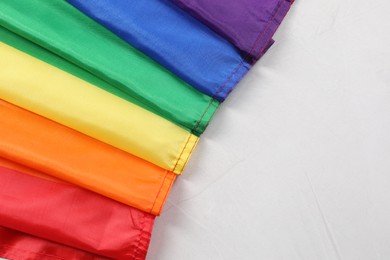 Photo of Rainbow LGBT flag on white background, top view. Space for text