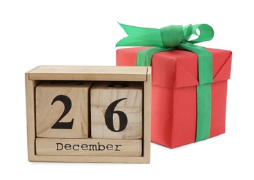Photo of Wooden block calendar with Boxing Day date and Christmas gift on white background