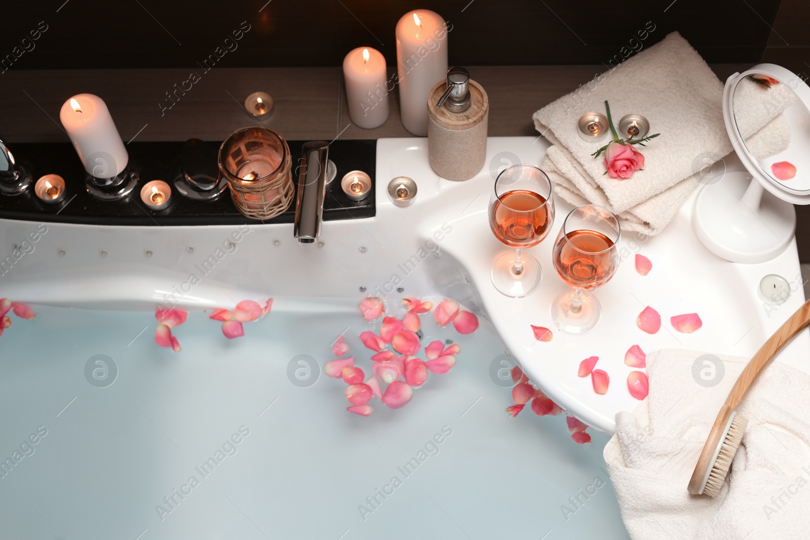 Photo of Bathtub with glasses of wine and candles indoors, above view. Romantic atmosphere