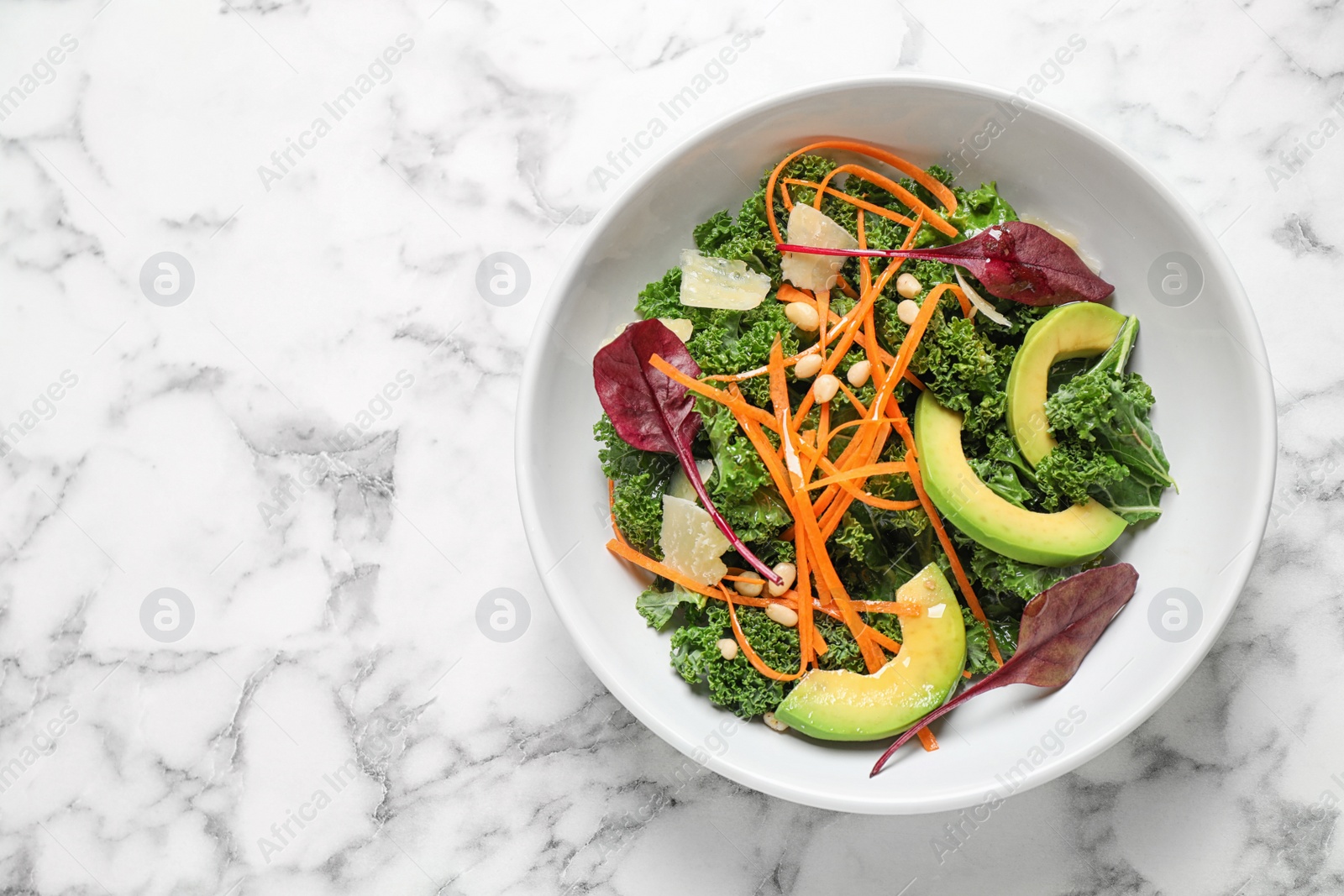 Photo of Tasty fresh kale salad on marble table, top view. Space for text