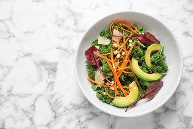 Photo of Tasty fresh kale salad on marble table, top view. Space for text